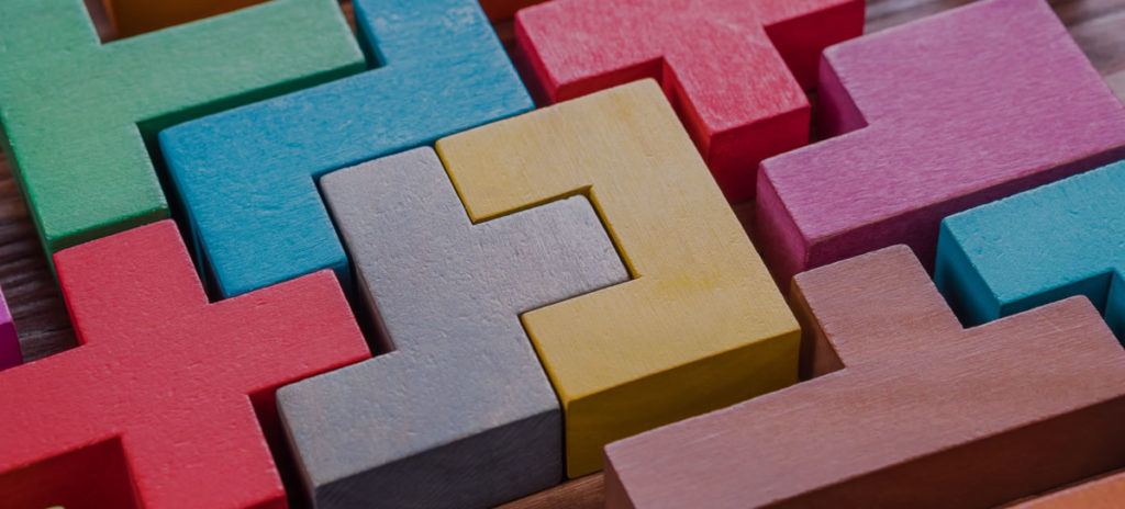 Closeup of close-fitting Tetris-style wooden blocks in many colors fitting loosely together