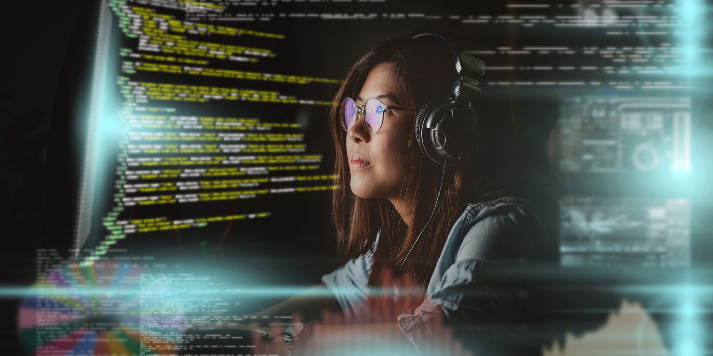 Asian Businesswoman working hard with front of computer desktop with programming source code and motion graphic over computer screen in work place at late times with exciting and serious action